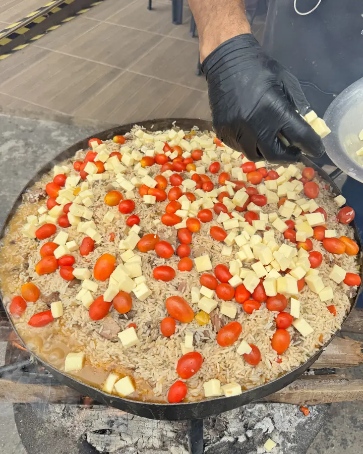 Mãos espalhando tomate-cereja no carreteiro